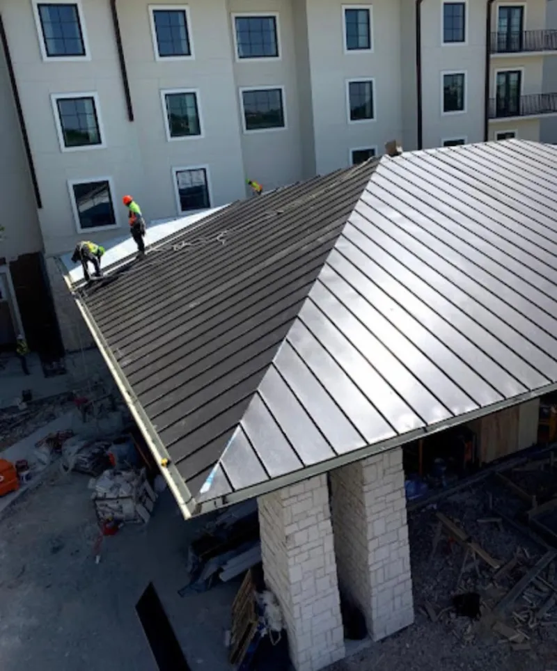 Crew installing standing seam metal roof panels on a commercial project in Vandenberg Village